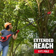 Photo of person using Craftsman pole saw CMCPPR320D1 outdoors to trim high tree branches, extended 8 ft. pole visible.